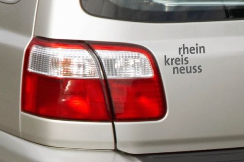 Ein Autoaufkleber mit dem Schriftzug "rhein kreis neuss"  in der Farbe anthrazit)